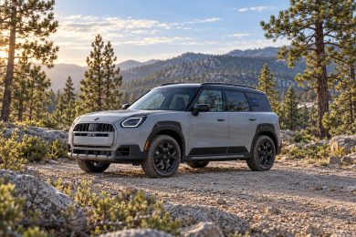 Grey MINI Countryman Untamed with a black roof parked on a rocky forest track.